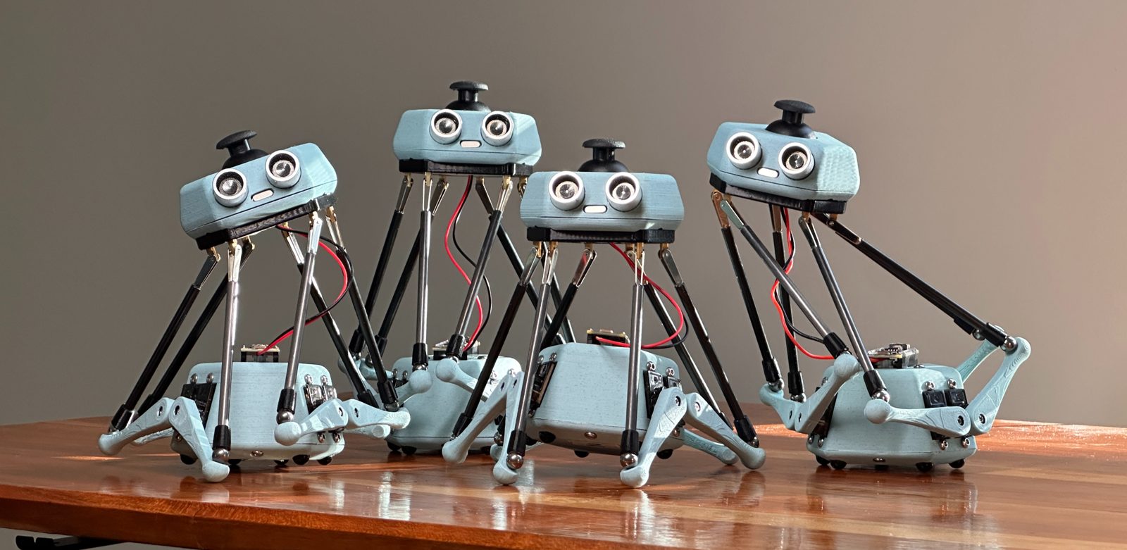 Several Stewy V2 robots standing on a wooden table